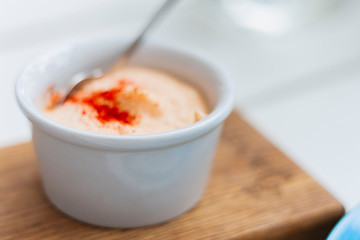 Sauce in small whire bowl for traditional meze dinner