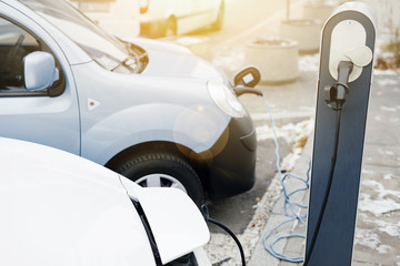 Electric car charging station. Close up of the power supply plugged into an electric car being charged. - Image