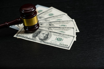 Judge's gavel on the background of dollar bills