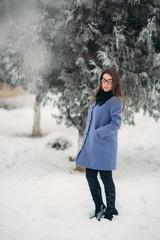 Beautiful girl in the winter outdoors. Girl is surrounded by snow-covered trees. Christmas mood. New year