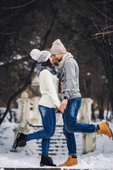 man and girl in sweaters hugging in the park in winter. winter walk, rest.