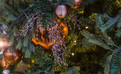 Obraz na płótnie Canvas Christmas tree closeup. Golden balls and illuminated garland with flashlights.