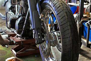 Fototapeta na wymiar Cropped close up shot of beautiful and custom made motorcycle in the workshop