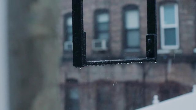 Rain bouncing of the fire escape ladders in slow mo
