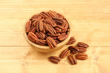 Pecan nuts in bamboo bowl on wooden table