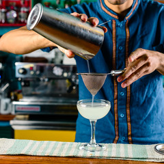 Fototapeta na wymiar bartender at the bar making a cocktail