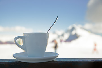 A cup of coffee on the background of snowy mountains