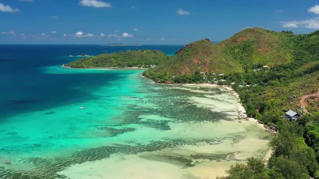 Aerial view of tropical paradise beach with white sand and turquoise crystal clear waters of Indian Ocean - Anse Possession, Praslin Island, Seychelles