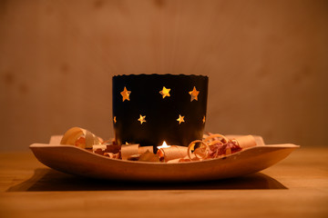 warm mood christmas tea light candle on wooden plate with shavings