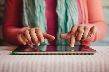 Young woman typing text on virtual keyboard in internet online on tablet