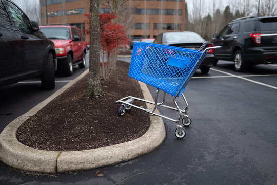 Empty blue shopping cart on the parking lot of the American mall center.
