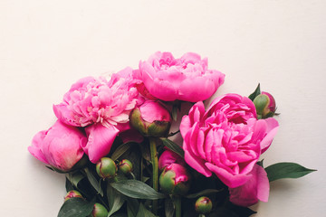 lovely pink peonies on rustic white wooden background top view, space for text. floral greeting card, flat lay. beautiful peony flowers pattern, tender image. happy mothers  day concept © sonyachny