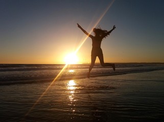 Mujer saltando en la playa