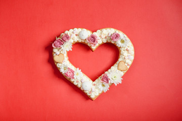 Valentine's Day heart-shaped cake with flowers as decoration. The concept of a gift to a loved one on a holiday.