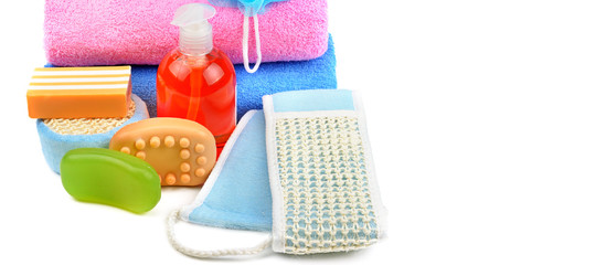 Cotton towels, cosmetic soap, sponge and shampoo isolated on white background. Wide photo.