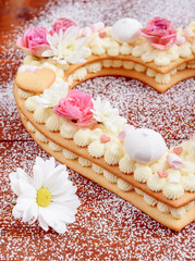 Obraz na płótnie Canvas Valentine's Day heart-shaped cake with flowers as decoration. The concept of a gift to a loved one on a holiday.