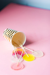 multi-colored lollipops on a pink background in a paper golden glass
