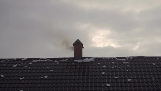 smoke goes out of the chimney house in winter