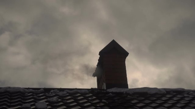 smoke goes out of the chimney house in winter