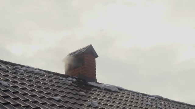 smoke goes out of the chimney house in winter