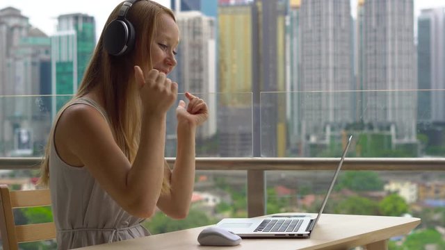 Remote techer has a conversation with a student through the internet at a balcony with a background of a city center full of skyscrapers. Student choosing e-learning program, easy effective self