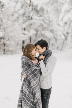  couple in love walking in the snowy forest, hugging, kissing and enjoying