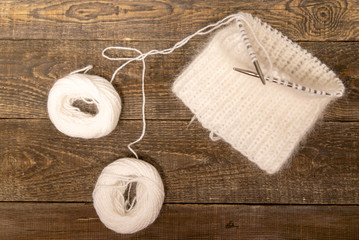 Fototapeta na wymiar light knitting on wooden background