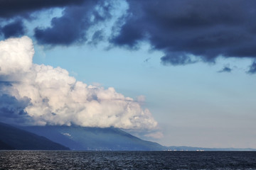 Fototapeta na wymiar Pyrocumulative and thunderclouds over the mountains and the sea