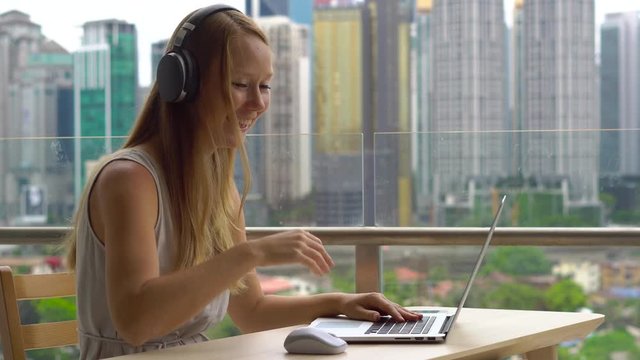 Remote techer has a conversation with a student through the internet at a balcony with a background of a city center full of skyscrapers. Student choosing e-learning program, easy effective self