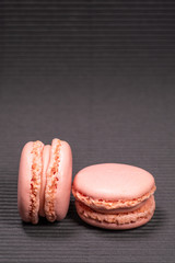 Colorful french macarons with strawberry flavor isolated on black background. Pastel colors - Image