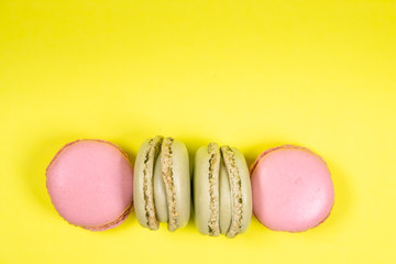 Colorful french macarons isolated on yellow background. Pastel colors - Imagen