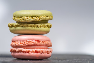 Assorted colorful french macarons isolated on white background placed on a slate stone. Pastel colors - Image