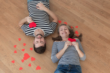 Top view young couple lying on the floor and looking to camera.