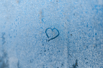 Heart on the frozen winter window in the frost
