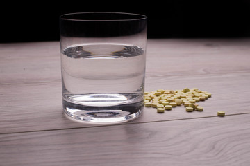 Tablets and a glass of water on the table