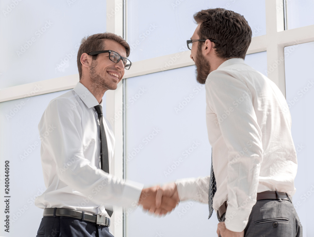 Wall mural cheerful colleagues shaking hands with each other.