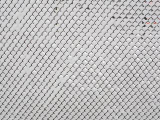 abstract pattern of snowy chain-link fence covered with snow, outdoor winter season shot
