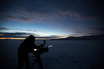 Obraz premium Silhouette of people who filming sunset in desert of Siberia.