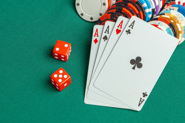Concept of gambling in casino, sports poker. Game cards with dice and colored chips sleep green game table.