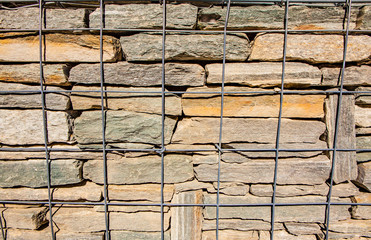 Metal grid in front of a stone wall