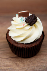 Chocolate, tasty and sweet cupcake with vanilla cream and condensed milk inside