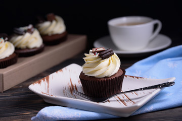 Chocolate, tasty and sweet cupcake with vanilla cream and condensed milk inside. Minimal food bakery concept.