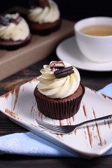 Chocolate, tasty and sweet cupcake with vanilla cream and condensed milk inside. Minimal food bakery concept.