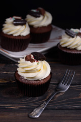 Chocolate, tasty and sweet cupcake with vanilla cream and condensed milk inside. Minimal food bakery concept.