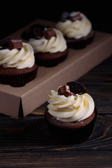 Chocolate, tasty and sweet cupcake with vanilla cream and condensed milk inside. Minimal food bakery concept.