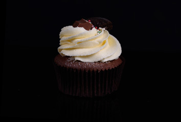 Chocolate, tasty and sweet cupcake with vanilla cream and condensed milk inside. Minimal food bakery concept.
