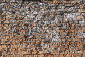 Brick wall texture background with red damaged old surface and white paint spots