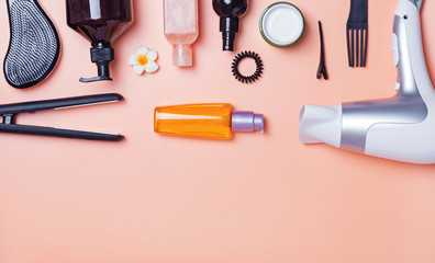 Hair care produts and styling items on orange background
