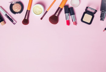 Brushes and make-up produts on the pink backgound