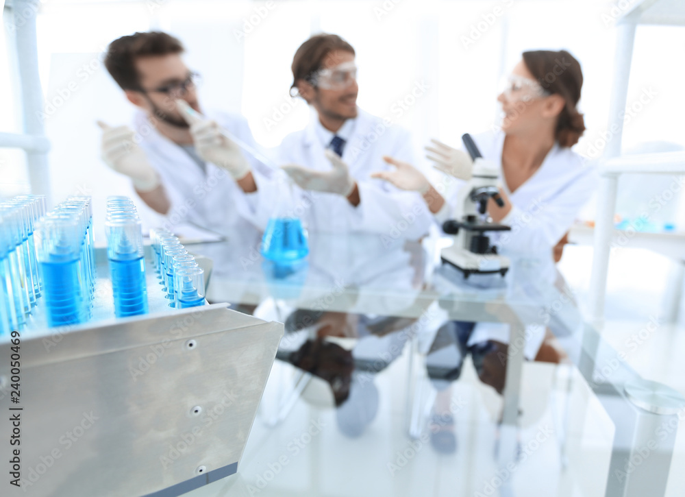 Wall mural background image of scientists studying blue liquid in a flask